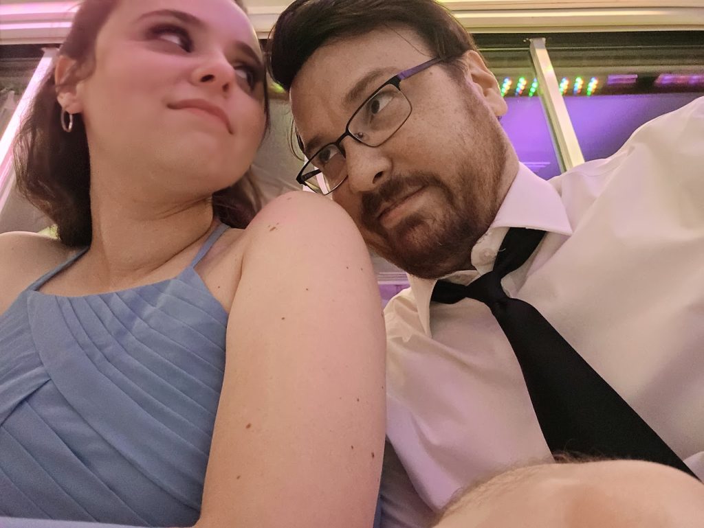 Richard making a silly face in dress shirt towards Francesca who is a radiant young woman.