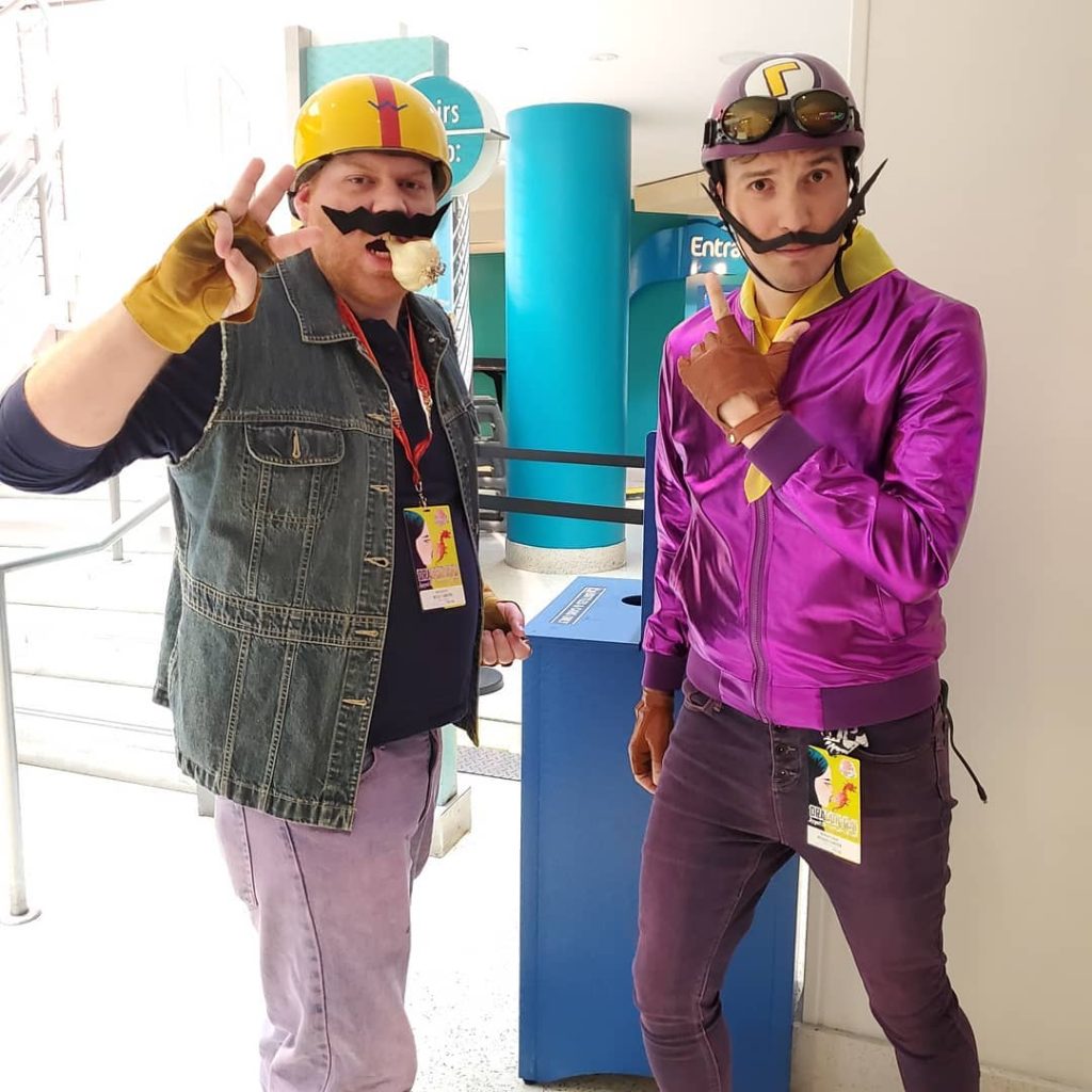 Wesley (left) and Richard (right) dressed as Wario and Waluig in that order, in biker gear at a convention.